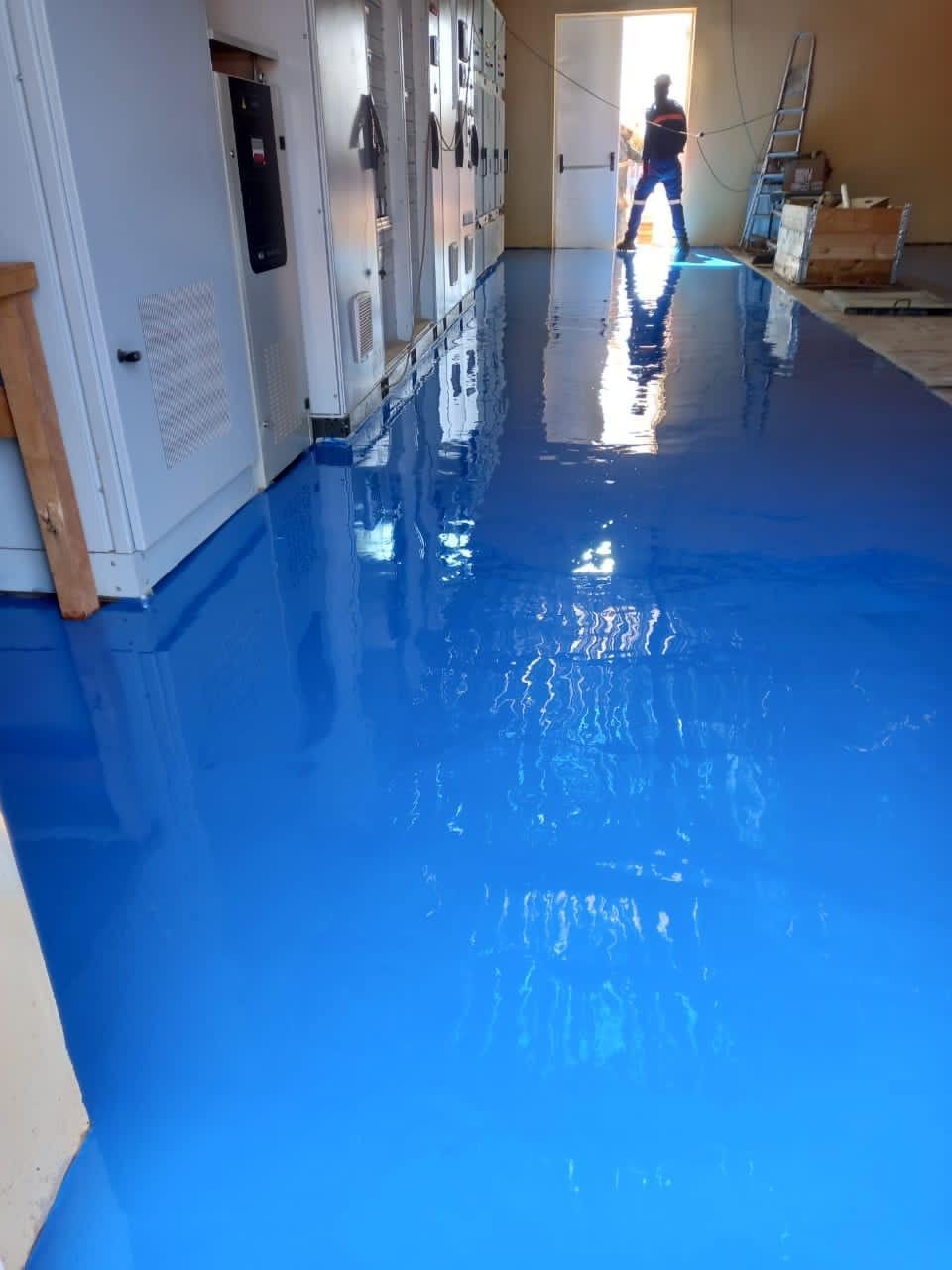 Résine époxy bleue dans un local électrique équipé d'armoires